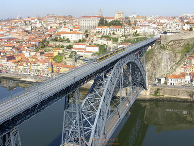 Blick auf die Altstadt von Porto mit Brücke über den Douro im Vordergrund und Standseilbahn rechts 